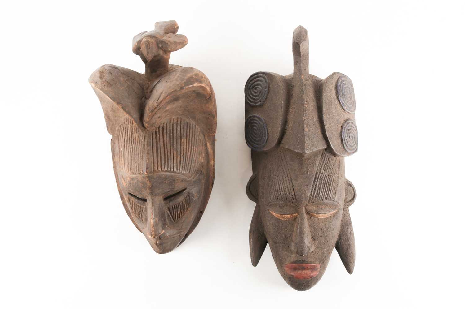 Two Ibo/Igbo Agbogho Mmwo masks, Nigeria, each with bird surmount, one with double arched coiffure