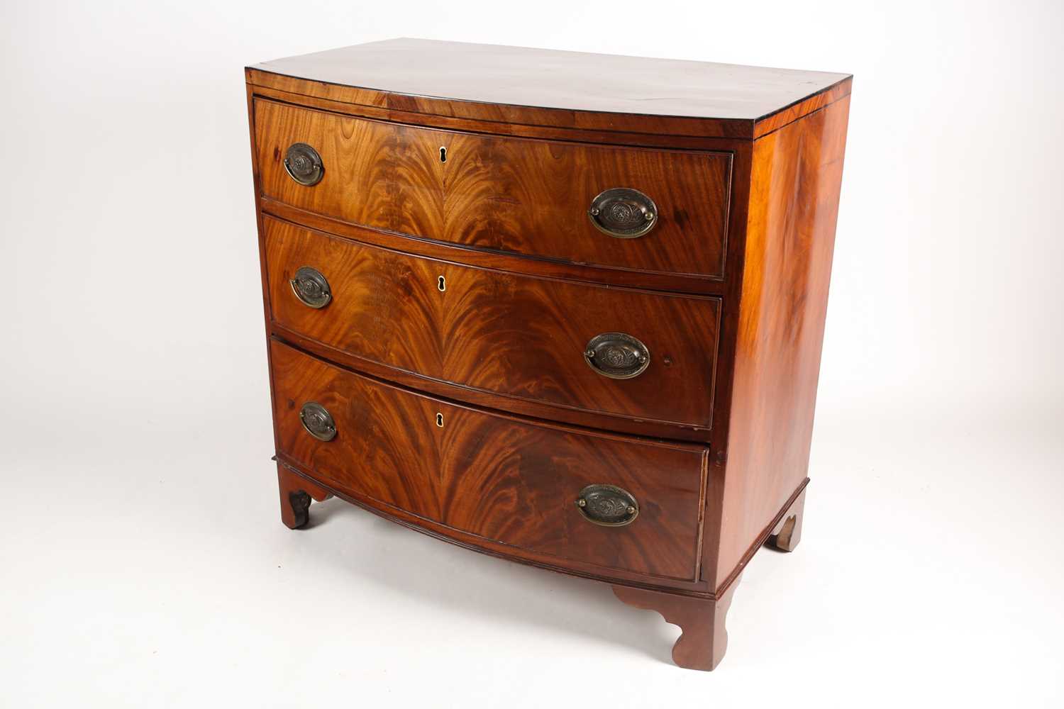 A reconfigured 19th-century mahogany caddy topped bowfront chest of three long drawers. Supported on