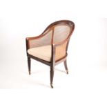 An early 19th century simulated rosewood hoop backed Bergere library chair with split can panel seat