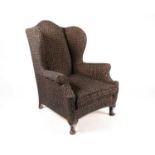 An early 20th-century wing chair with rollover arms and supported on squat cabriole legs. 77 cm wide