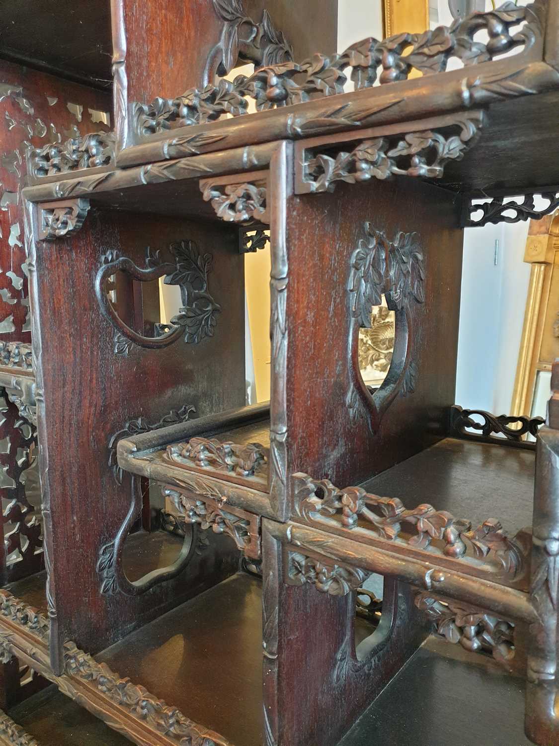 A Chinese hongmu open cabinet, early 20th century, carved throughout with Dogs of Fo, fruiting - Image 19 of 22