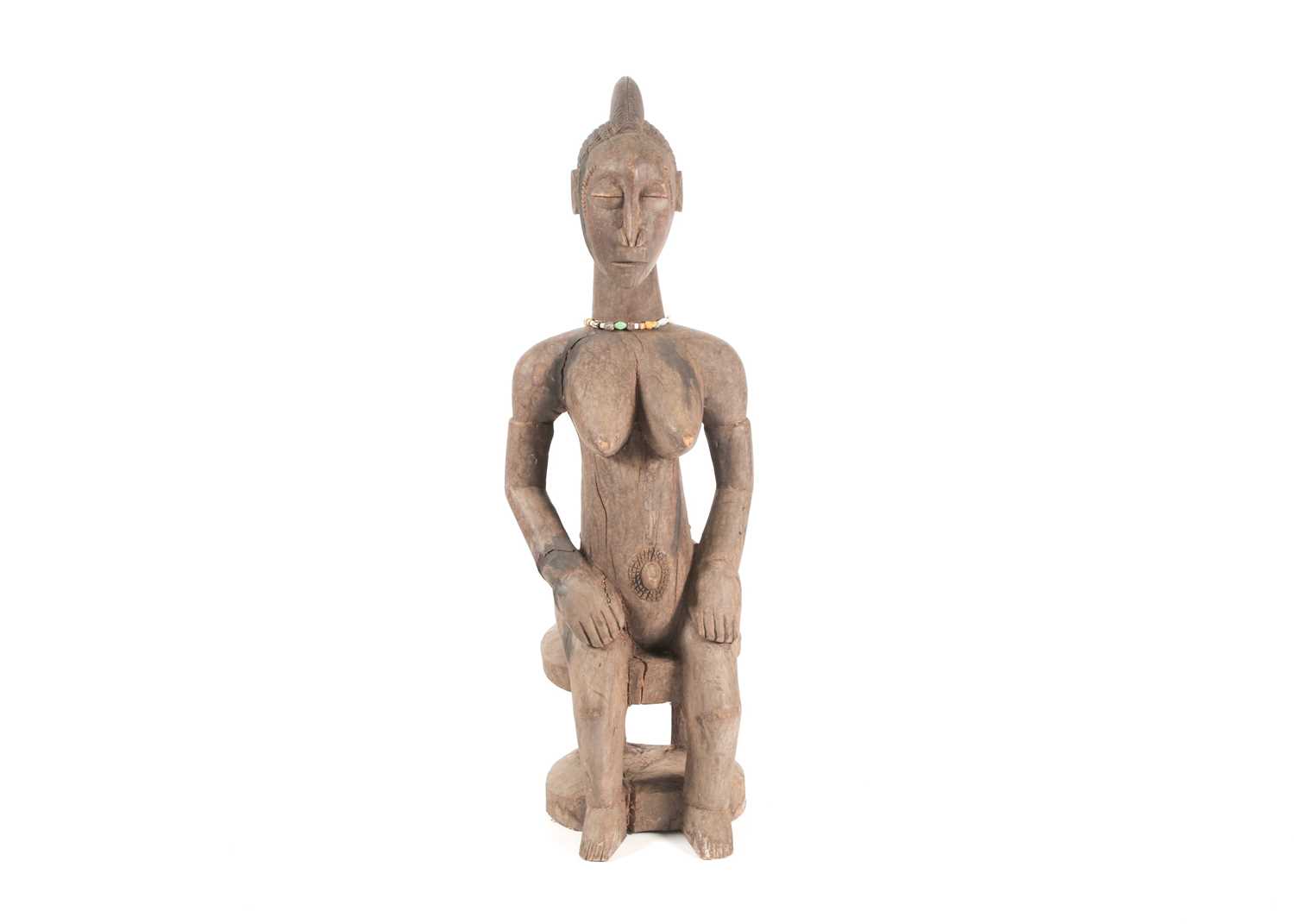 A Baule seated maternity figure, Ivory Coast, with linear and chevron coiffure, scarifications