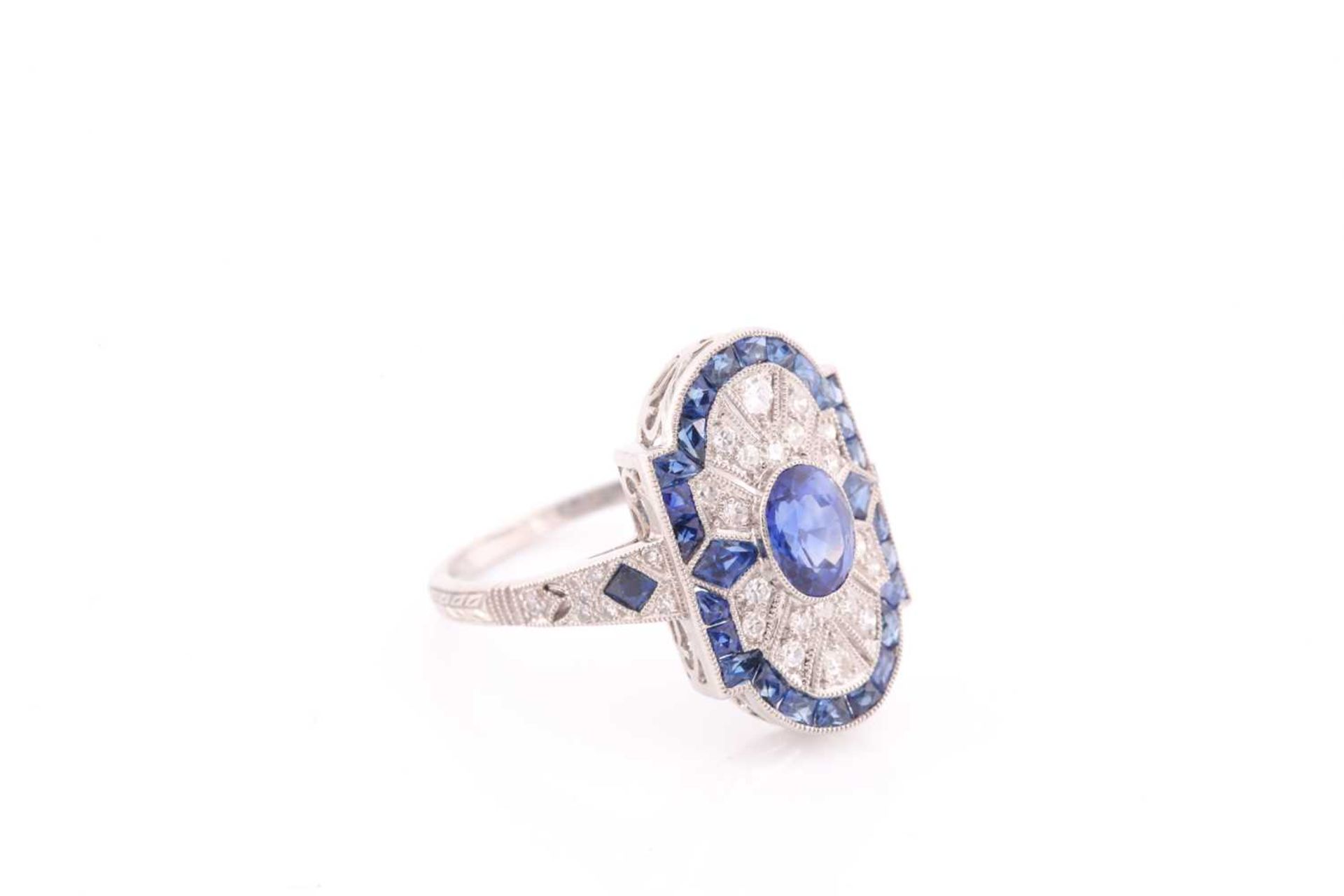 A platinum, diamond, and sapphire plaque ring, in the Art Deco style, centred with a mixed oval- - Image 3 of 4