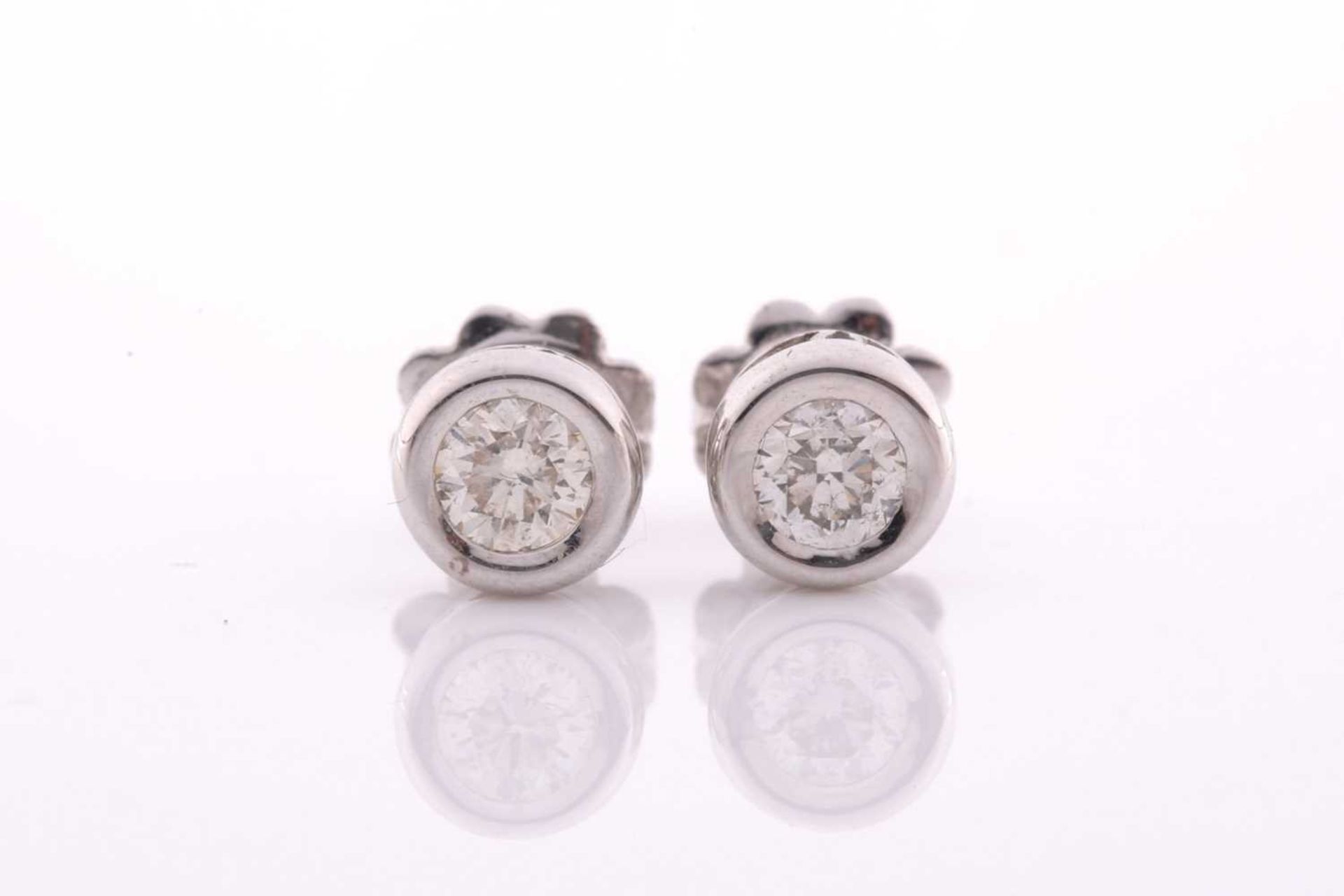 A pair of collet-set diamond solitaire ear studs, set with round brilliant-cut diamonds of