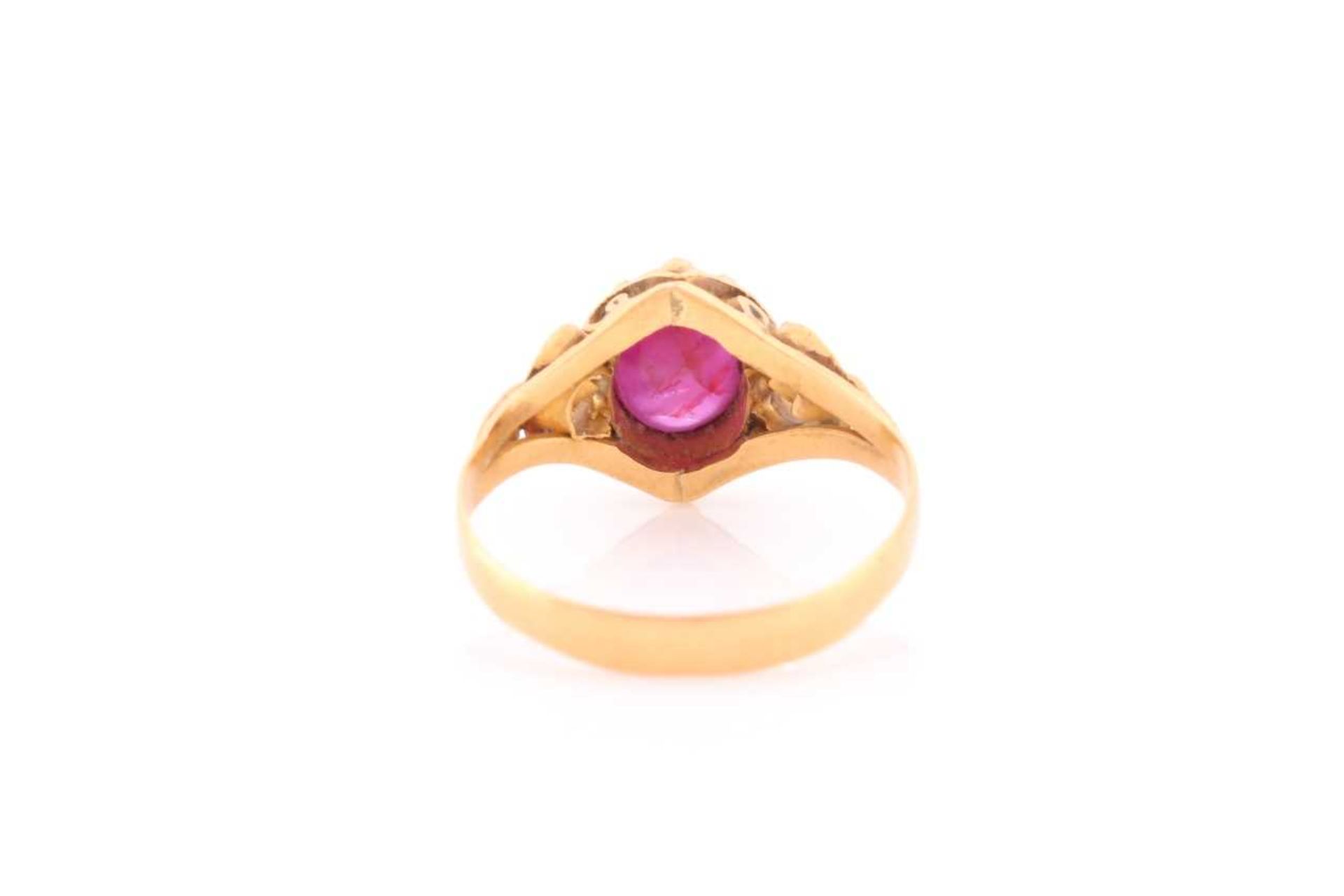 A yellow metal and ruby ring, set with a cabochon six-pointed star ruby, in an ornate antique- - Image 2 of 4