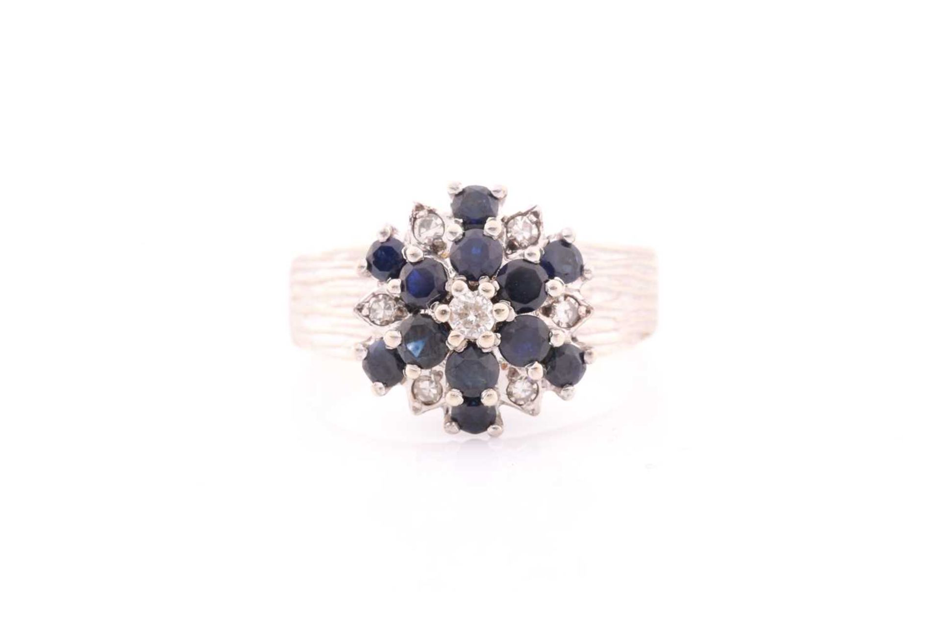 An 18ct white gold, diamond, and sapphire cluster ring, set with a cluster of round-cut sapphires