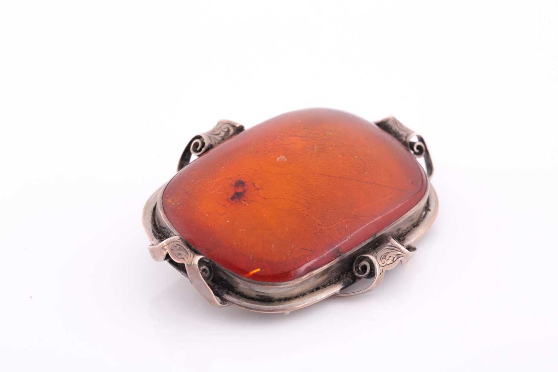 An Art Nouveau silver and amber brooch, the large rectangular single stone amber plaque withing an - Image 2 of 3