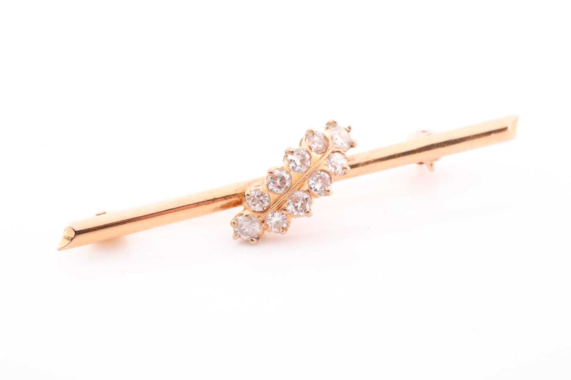 A yellow metal and diamond bar brooch, set with ten round brilliant-cut diamonds of approximately