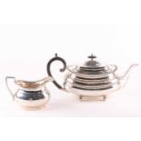 A George VI silver boat form teapot and a similar cream jug, the teapot Sheffield 1938 by Harrods of