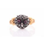 A yellow metal and diamond ring, in the form of an owl's face, the silvered face inset with cabochon