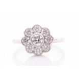 A platinum and diamond daisy cluster ring, set with round-cut diamonds of approximately 1.0 carats