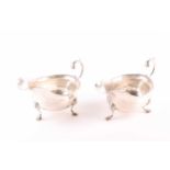A pair of Edwardian silver gravy boats of George II style, London 1908, maker not found, with leaf