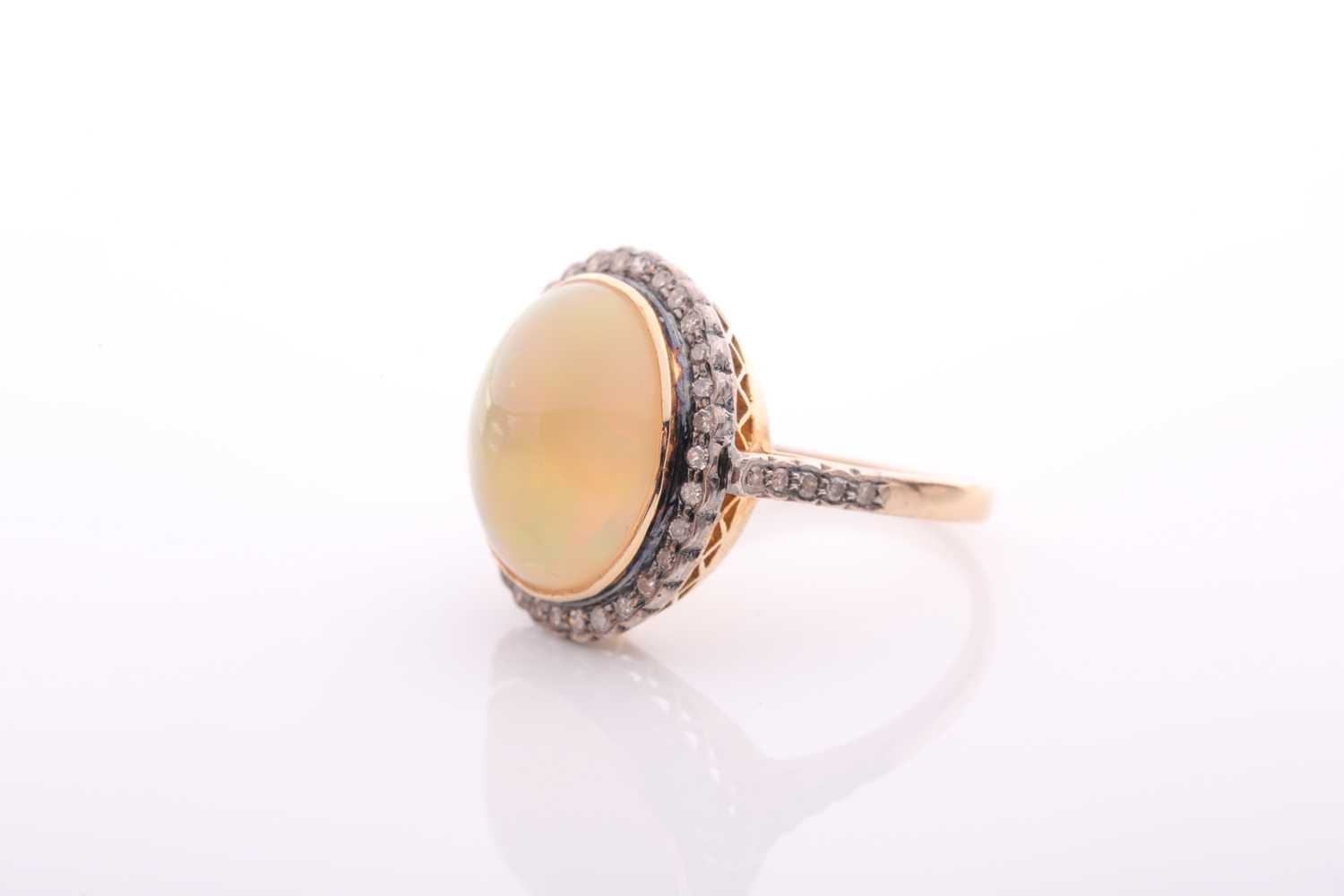 A modern opal and diamond oval cluster ring, centred with an oval cabochon Ethiopian ‘Melo’ opal, - Image 5 of 5