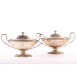 A pair of mostly early 19th century (re-assayed) silver oval pedestal tureens and covers, re-assay