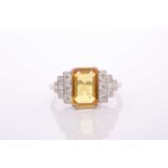A modern treated yellow sapphire and diamond dress ring, centred with a rectangular step-cut