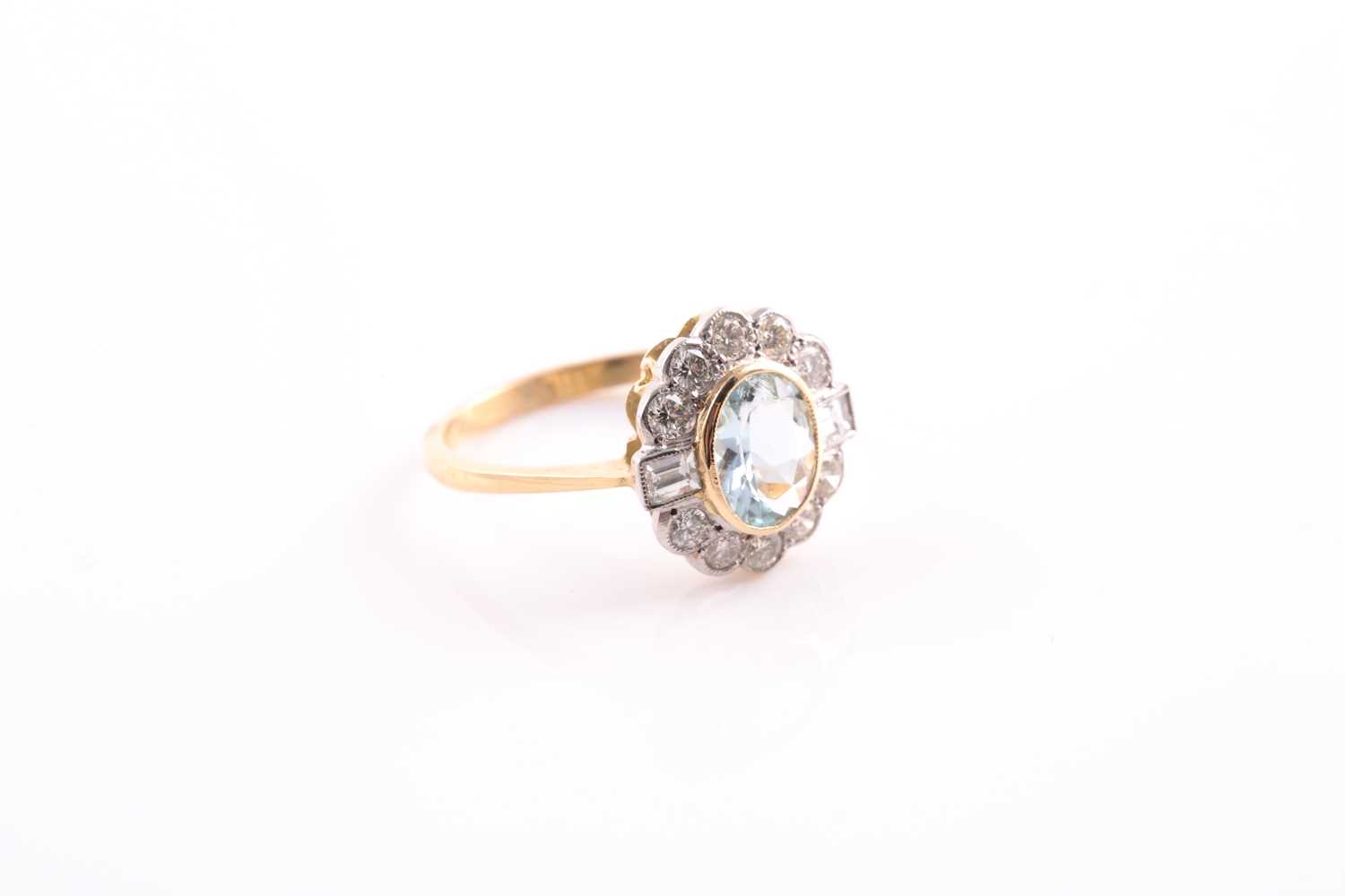 An aquamarine and diamond cluster ring; the oval cut aquamarine in rub over mount within a border of - Image 3 of 4