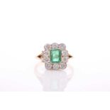 An emerald and diamond rectangular cluster ring, centred with an emerald-cut emerald,