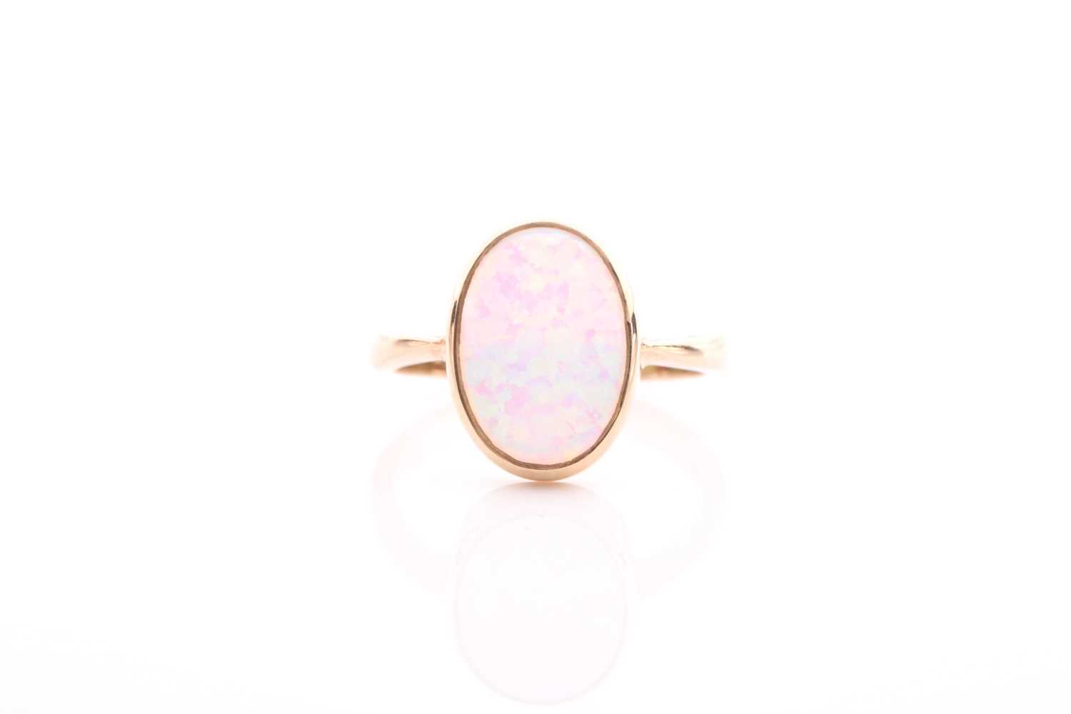 A single stone opal ring, the oval opal in rub-over mount to plain 9 carat gold shank, opal 14mm x