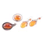 Two silver and pressed amber brooches, together with a pair of silver and amber drop earrings, and a