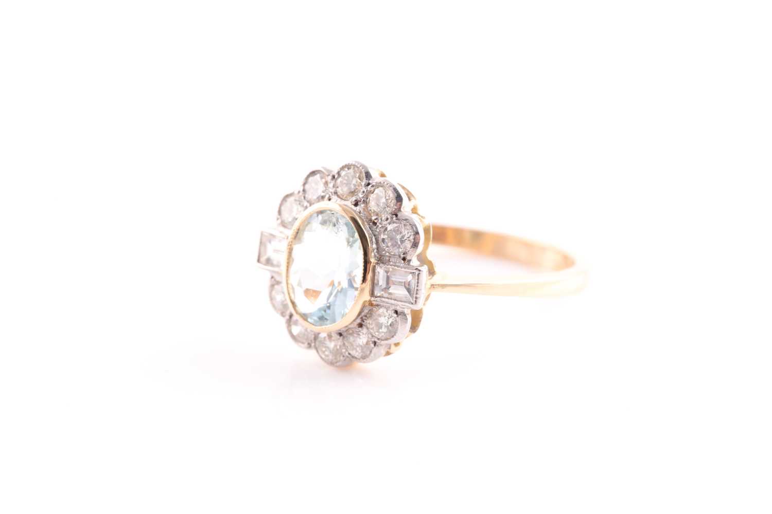 An aquamarine and diamond cluster ring; the oval cut aquamarine in rub over mount within a border of - Image 4 of 4