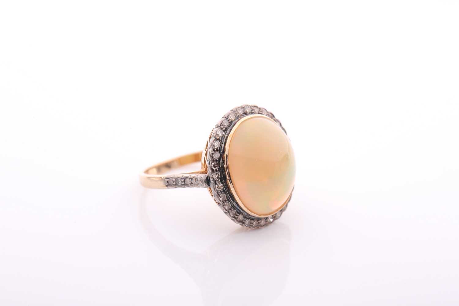 A modern opal and diamond oval cluster ring, centred with an oval cabochon Ethiopian ‘Melo’ opal, - Image 2 of 5