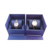 Two Swarovski lady's watches, both with round white dials and crystal set stainless steel mounts and