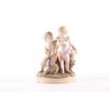 A late 19th century Meissen porcelain figure of two putti with floral garland and perched parrot. On