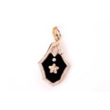 An onyx and diamond pendant / brooch, the shield-shaped onyx plaque with applied diamond foliate
