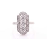 A diamond and platinum ring, the plaque-shaped ring centred with three round brilliant-cut