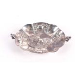 A small Continental silver bon bon dish, the lobed body embossed with fruits, with two scroll