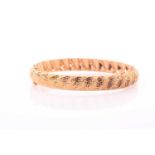 A 9ct yellow gold bangle, of twisted design with textured finish, marked 9k, internal diameter 6.8