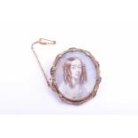 An early 19th century portrait miniature in a gold brooch mount, the oval ivory plaque depicting a