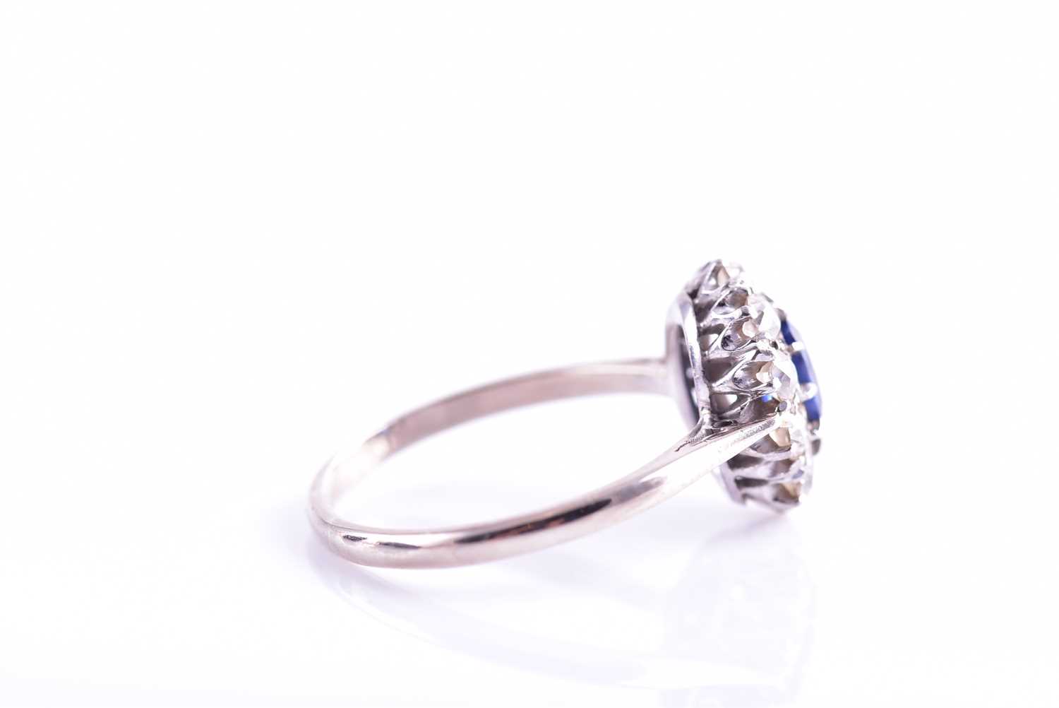 A diamond and sapphire cluster ring, set with a mixed oval-cut blue sapphire of approximately 1.10 - Image 3 of 4