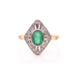 A yellow metal, diamond, and emerald ring, set with a mixed oval-cut emerald, bezel-set within an