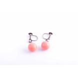 A pair of diamond and coral drop earrings, each suspended with a rounded coral bead, approximately