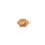 A yellow metal signet ring, the rectangular mount with engraved decoration, stepped shoulders,