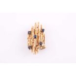 A five stone sapphire brooch, of naturalistic Modernist design; the circular cut sapphire set