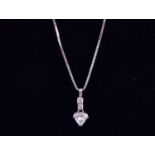 A white metal and diamond drop pendant, set with a heart-shaped diamond, measuring approximately 6