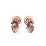 A pair of vintage tri-coloured yellow metal and ruby ear clips; in the form of a stylised knot, each