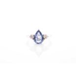 A sapphire and diamond three stone half hoop ring; the central pear-shaped sapphire in simple claw