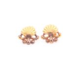 A pair of yellow metal earrings, of shell design, screwback fastens, unmarked, 1.7 cm wide.Condition