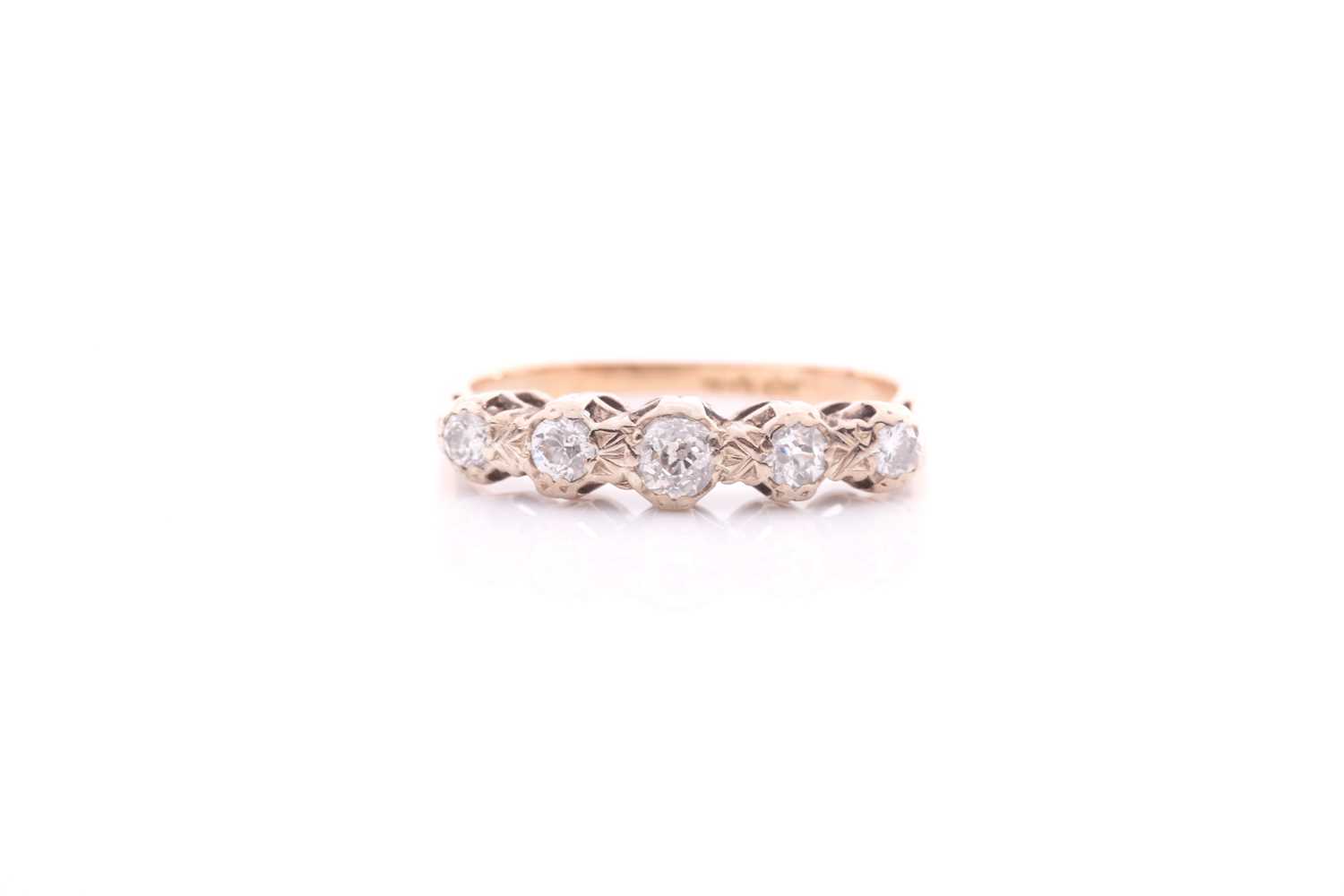 A five stone half hoop diamond ring; the graduated mixed old brilliant cut stones in carved claw