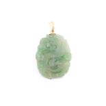 A Chinese green jade pendant, with carved and pierced swirled decoration, suspended on a yellow