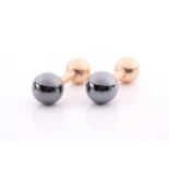 Tiffany. A pair of barbell style yellow metal and hematite cufflinks, the graduated spherical