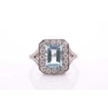 A platinum, diamond, and aquamarine ring, set with an emerald-cut aquamarine of approximately 2.0