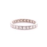 A full hoop diamond eternity ring; the round brilliant cut diamond claw mounted within channel