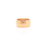 A yellow metal band ring, with repousse decoration, unmarked, size K.Condition report: 5.8 grams.