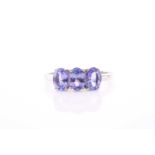A 9ct yellow gold and tanzanite ring, set with three mixed oval-cut tanzanite, each stone