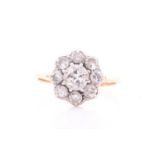 A diamond cluster ring; the principal old brilliant cut diamond claw mounted within a border of