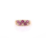 An 18ct yellow gold, diamond, and ruby ring, rubover set with mixed round-cut rubies and old-cut